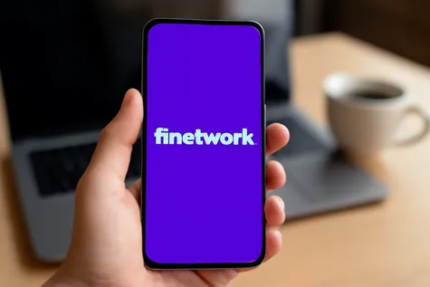 Mano sosteniendo móvil con fondo morado y la palabra "Finetwork" en blanco centrada en pantalla