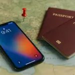 Móvil con fondo de iPhone, mapa y pasaportes sobre mesa listos para viajar